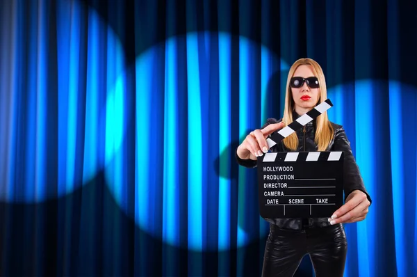 Menina com placa de filme contra cortinas — Fotografia de Stock