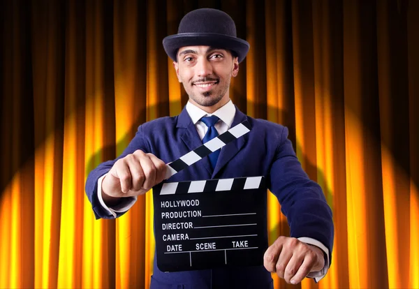 Man met film klepel op gordijn achtergrond — Stockfoto