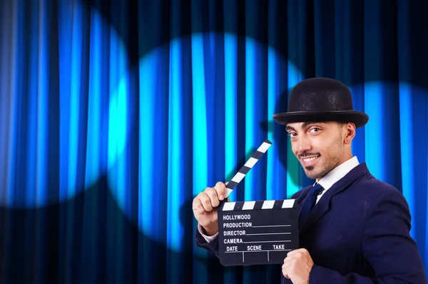 Man with movie clapper on curtain background — Stock Photo, Image