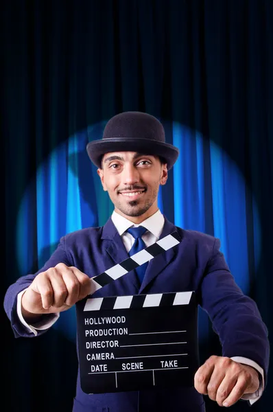 Man with movie clapper on curtain background — Stock Photo, Image
