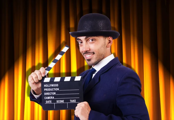 Hombre con película clapper en fondo de cortina —  Fotos de Stock