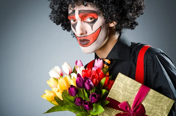Trauriger Clown mit den Blumen — Stockfoto