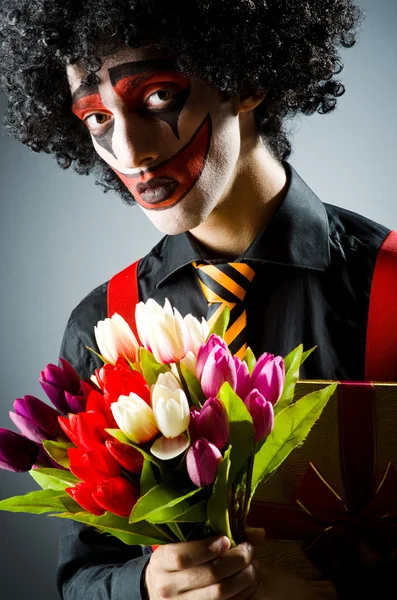 Sad clown with the flowers — Stock Photo, Image