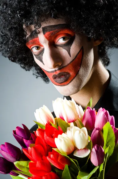 Trauriger Clown mit den Blumen — Stockfoto