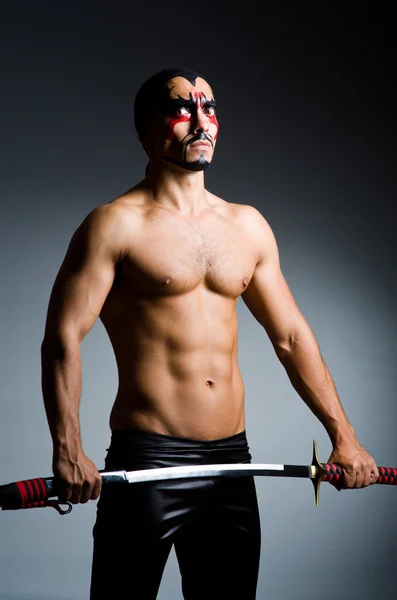 Man with sword and face paint — Stock Photo, Image