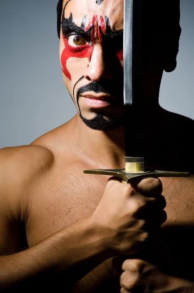 Homme avec épée et peinture de visage — Photo