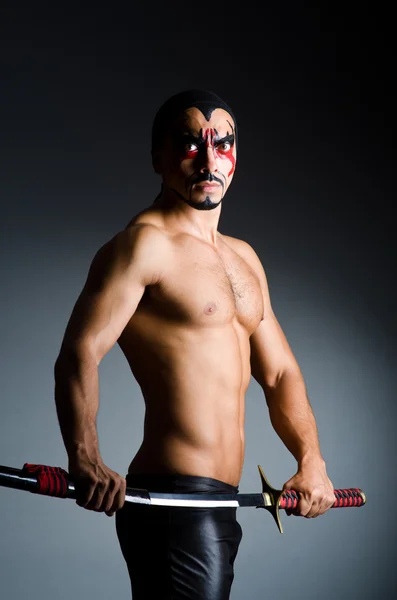 Man with sword and face paint — Stock Photo, Image