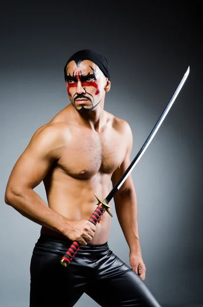 Man met zwaard en gezicht verf — Stockfoto