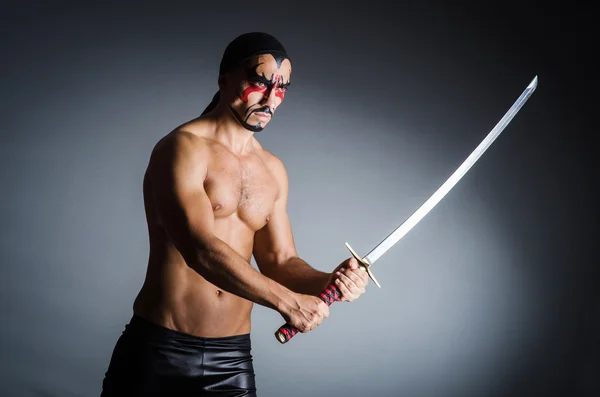 Man with sword and face paint — Stock Photo, Image