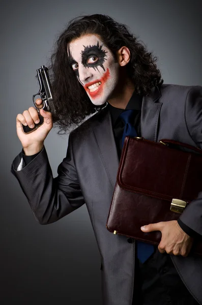 Joker met pistool en werkmap — Stockfoto