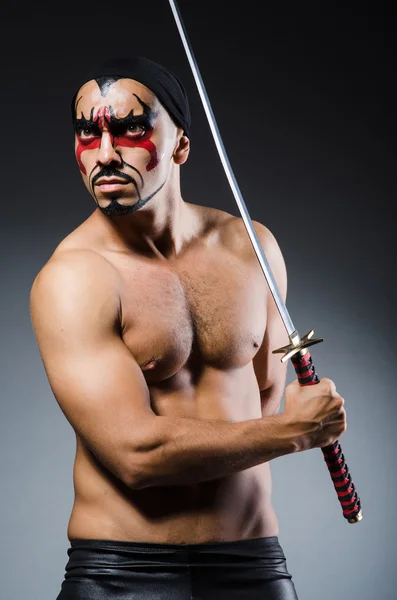 Man with sword and face paint — Stock Photo, Image