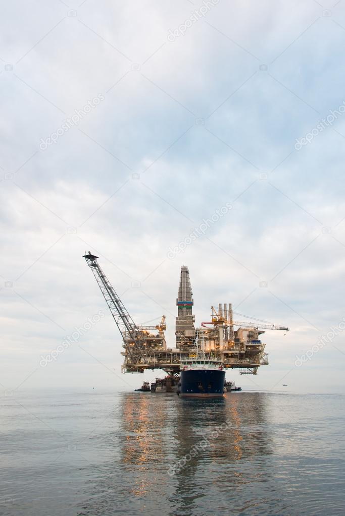 Oil rig being tugged in the sea