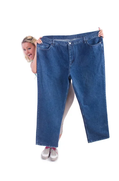 Kvinna i bantningskoncept med stora jeans — Stockfoto