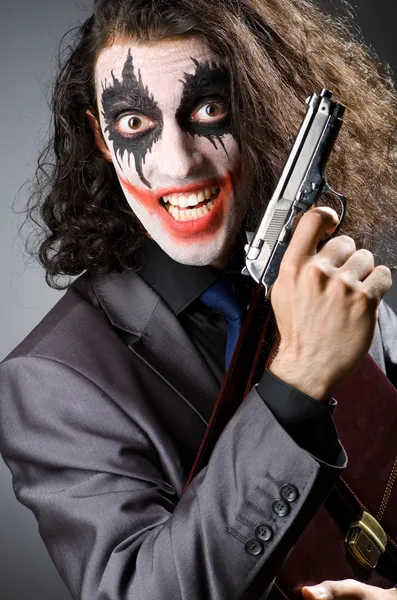 Joker with gun and briefcase — Stock Photo, Image
