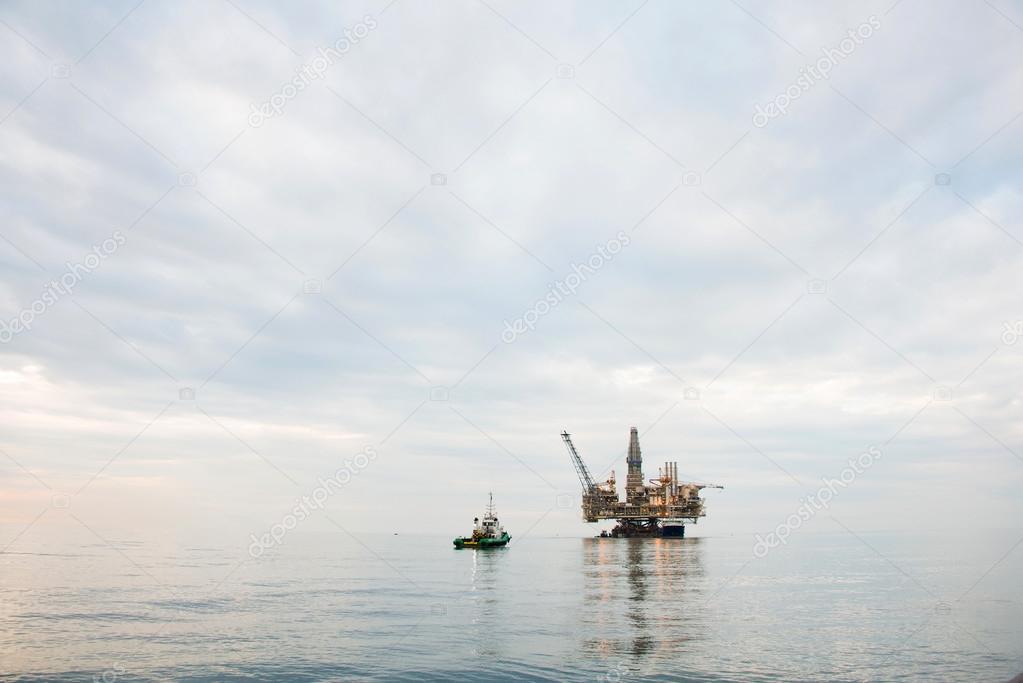 Oil rig being tugged in the sea