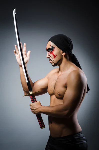 Man met zwaard en gezicht verf — Stockfoto