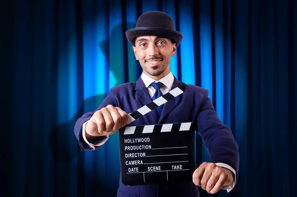 Man with movie clapper on curtain background — Stock Photo, Image