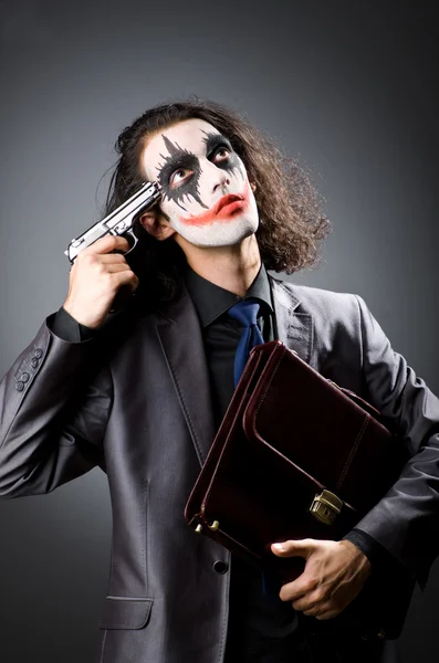 Joker met pistool en werkmap — Stockfoto