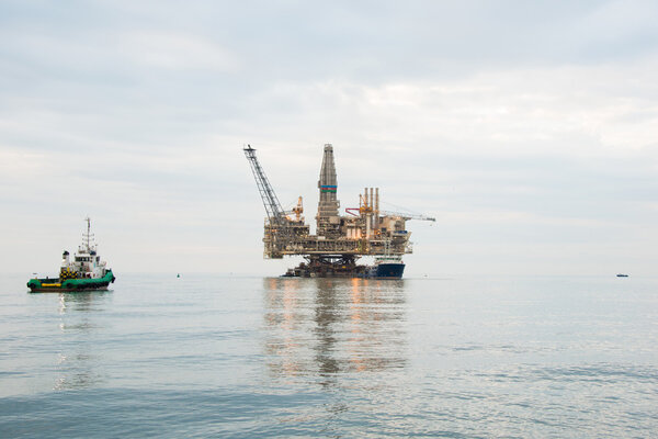 Oil rig being tugged in the sea