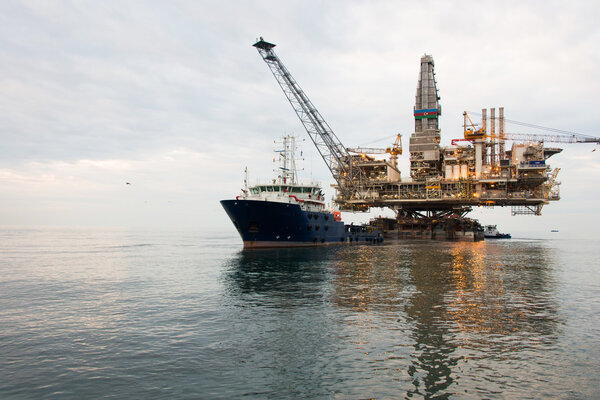 Oil rig being tugged in the sea