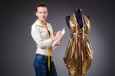 Kadın terzi elbise üzerinde çalışıyor.