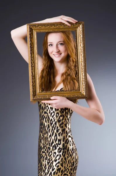 Redhead with picture frame against dark background — Stock Photo, Image