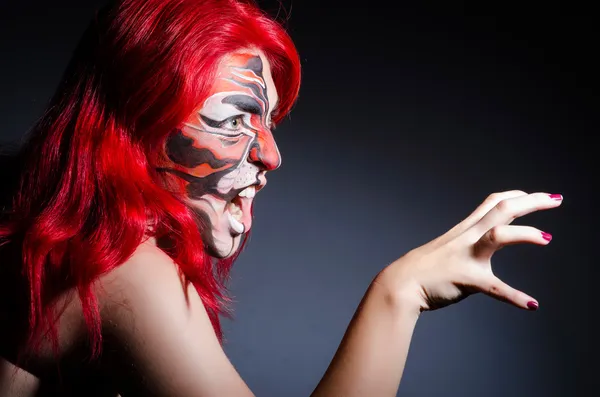 Mujer con pintura facial en habitación oscura — Foto de Stock