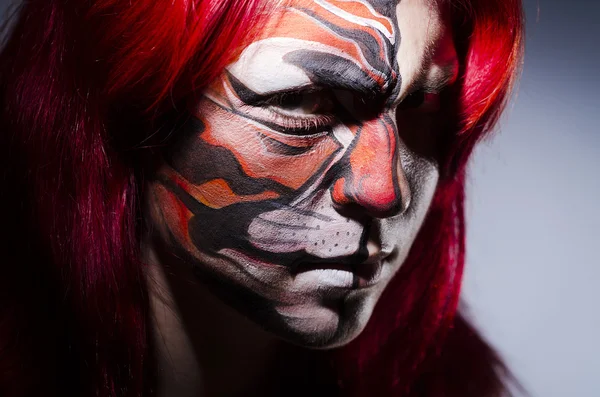 Femme avec peinture sur le visage dans la chambre noire — Photo