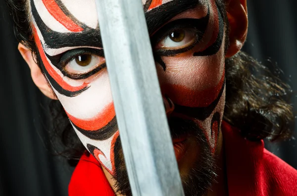 Man met zwaard en gezicht masker — Stockfoto