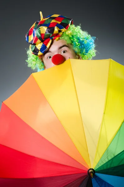 Lustiger Clown mit buntem Regenschirm — Stockfoto