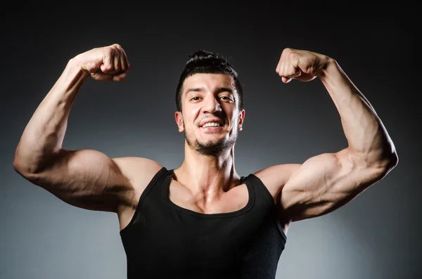 Homem muscular posando em estúdio escuro — Fotografia de Stock