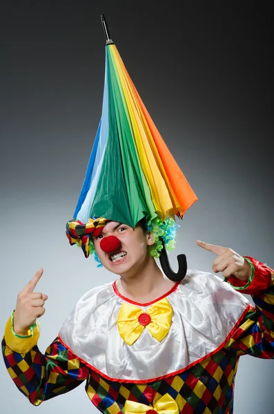 Grappige clown met kleurrijke paraplu — Stockfoto