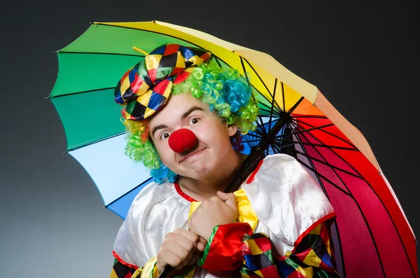 Grappige clown met kleurrijke paraplu — Stockfoto