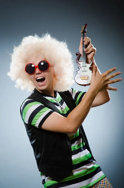 Hombre divertido con guitarra en miniatura — Foto de Stock