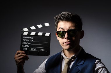 Elinde film tahtası olan komik bir adam.