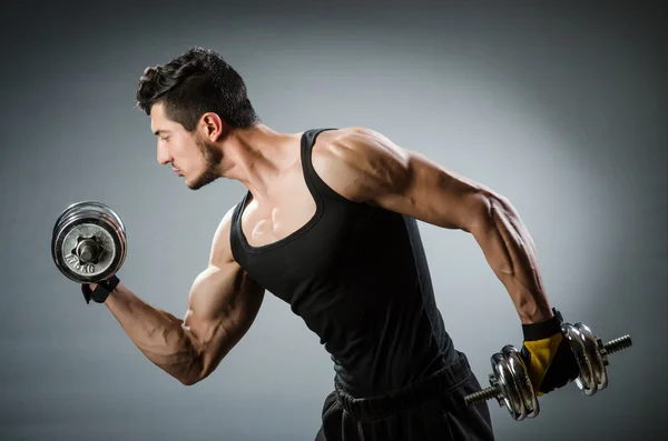 Muscular fisiculturista rasgado com halteres — Fotografia de Stock