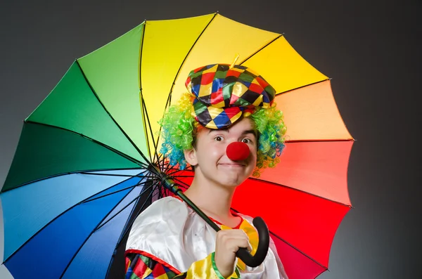 Grappige clown met kleurrijke paraplu — Stockfoto