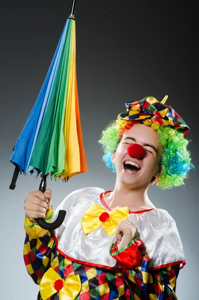 Lustiger Clown mit buntem Regenschirm — Stockfoto