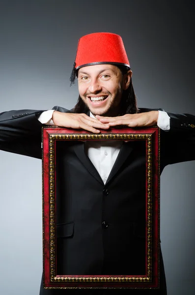 Man with fez  hat and picture frame — Stock Photo, Image