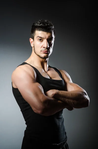 Hombre musculoso posando en estudio oscuro — Foto de Stock