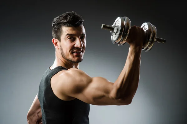 Muscular fisiculturista rasgado com halteres — Fotografia de Stock