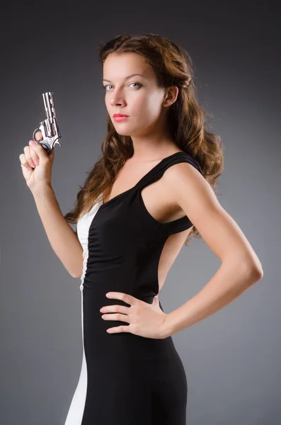Frau mit Waffe vor dunklem Hintergrund — Stockfoto