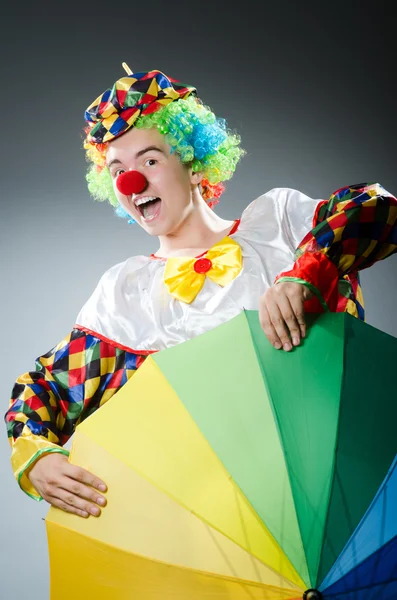 Grappige clown met kleurrijke paraplu — Stockfoto