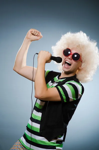 Man in afrowig singing with mic — Stock Photo, Image