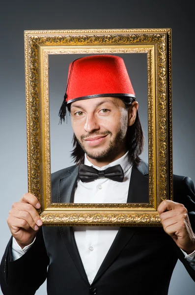 Hombre con sombrero fez y marco de imagen — Foto de Stock