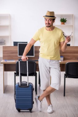 Genç bir erkek işçi iş yerinde geziye hazırlanıyor.