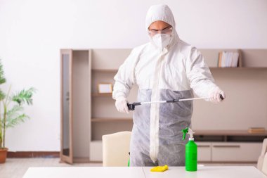 Genç erkek müteahhit evde haşere kontrolü yapıyor.