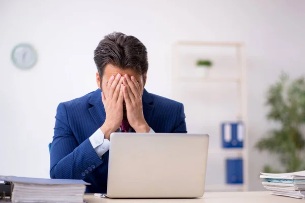 Jovem funcionário masculino infeliz com excesso de trabalho no escritório — Fotografia de Stock