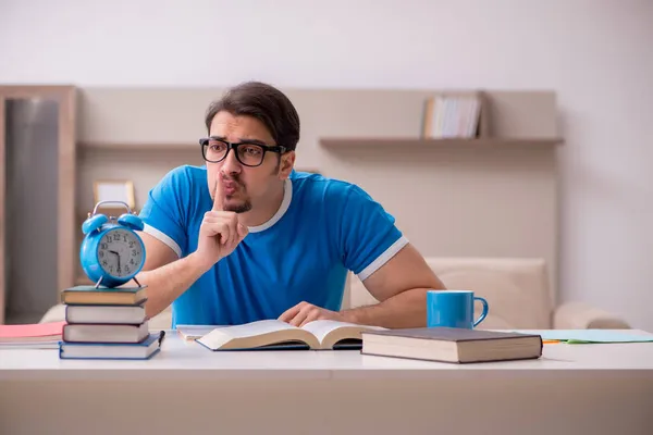 Joven estudiante masculino que estudia en casa en concepto de gestión del tiempo — Foto de Stock