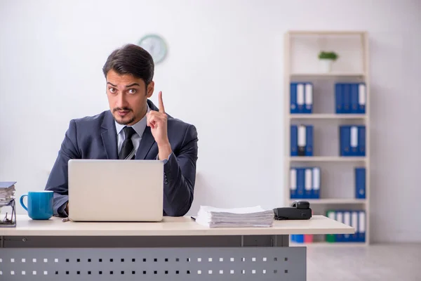 Jovem trabalhador masculino sentado no local de trabalho — Fotografia de Stock